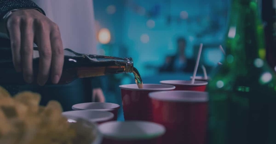 pouring drinks into red cups fraternity sorority