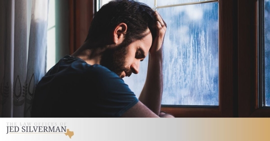 Caucasian man holding his head in his left hand