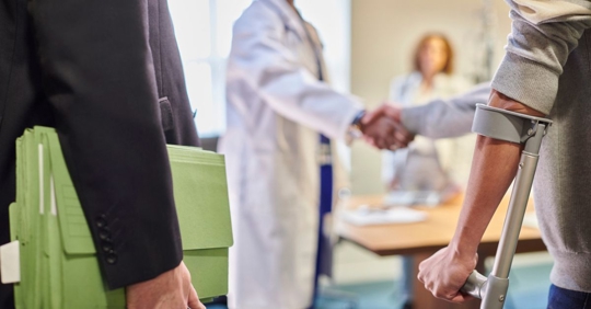injured person shaking hands with a doctor